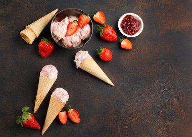 Koyu renkli arka planda waffle külahlı ev yapımı çilekli dondurma. Sağlıklı yaz yemekleri konsepti. Üst görünüm, kopyalama alanı, düz uzanma.