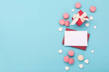 Sevgililer Günü için zarif bir kompozisyon. Beyaz parıldayan kalpler, hediye kutusu, mavi arka planda tatlılar. Sevgililer Günü, Mutlu Kadınlar Günü, Anneler Günü konsepti. Düz konum, üst görünüm, kopyalama alanı.