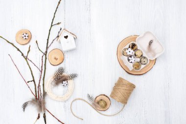 Zero waste Easter background on white wooden table. Quail Easter eggs, natural Spring decorations, cotton flowers and pussy willow branches. Top view, copy space. Eco friendly lifestyle.