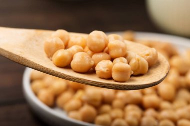 Koyu ahşap arka planda nohut pişirdim. Seçici odak, uzayı kopyala. Sağlıklı, besleyici ve vejetaryen gıda konsepti.