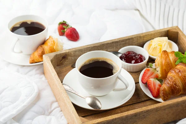 침대에서 아침을 커피와 크로와 딸기를 먹는다 호텔에서 — 스톡 사진