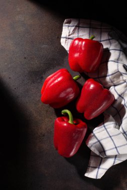 Yemek pişirme geçmişi. Taze kırmızı biber ve koyu kırsal ahşap arka planda tekstil beyazı mavi havlu. Üst görünüm, alanı kopyala