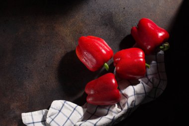 Yemek pişirme geçmişi. Taze kırmızı biber ve koyu kırsal ahşap arka planda tekstil beyazı mavi havlu. Üst görünüm, alanı kopyala