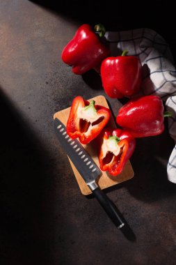 Yemek pişirme geçmişi. Taze kırmızı biber ve koyu kırsal ahşap arka planda tekstil beyazı mavi havlu. Üst görünüm, alanı kopyala