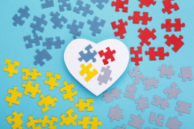 Dünya Otizmi farkındalık günü geçmişi. 2 Nisan Dünya Otizm Farkındalık Günü için yaratıcı tasarım. Yapboz rengi yapboz elementi ve beyaz kağıt kalp. Üst görünüm, metin için boşluk kopyala.