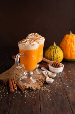 Koyu ahşap arka planda krem şantili balkabağı aromalı latte. Seçici odaklanma. Tatil hasadı sonbahar konsepti