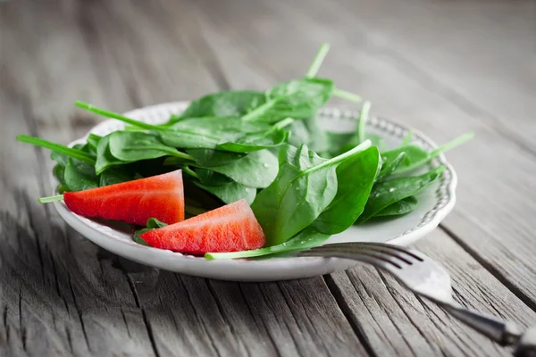 Fresh spinach leaves with strawberries — Stock Photo, Image