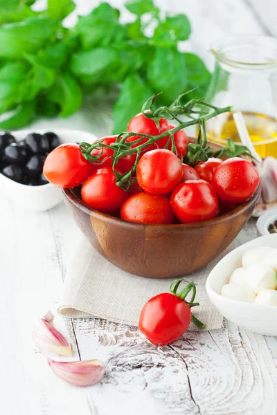 Tomatoes and mozzarella with basil leaves — Stock Photo, Image