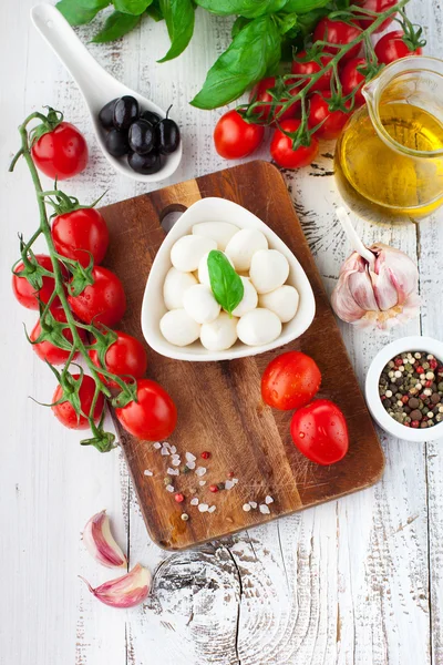 Tomates e mussarela com folhas de manjericão — Fotografia de Stock