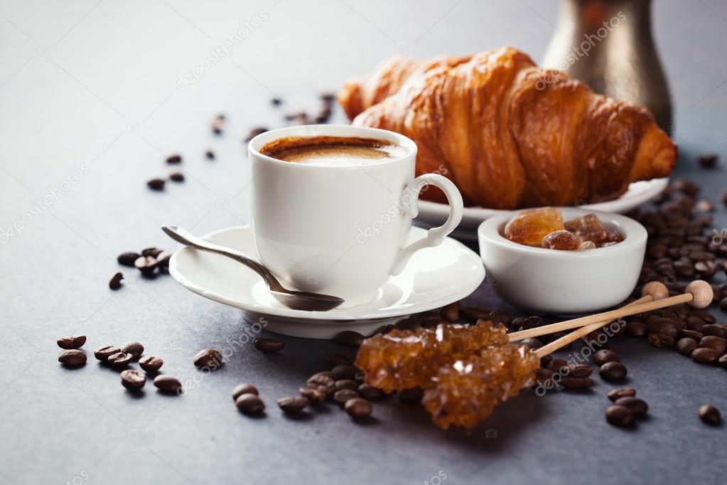 Fresh croissants  and cup of coffee on a table