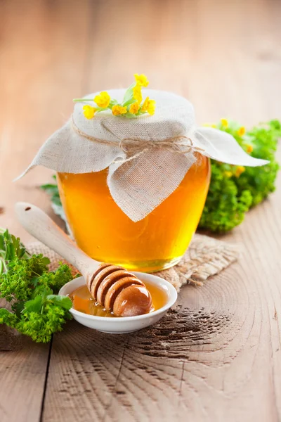 Pot of honey and wooden stick — Stock Photo, Image