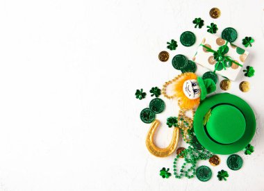 Aziz Patrick Günü tatili için en üstte yeşil nesneler, yonca sembolleri ve kopyalama alanı var. Pankartlar, posterler, selamlar, mevsimlik pazarlama ve tatil geçmişi tasarımı için. Beyaz taş arkaplan