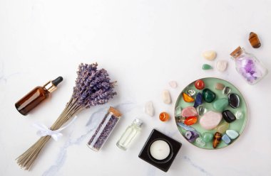 Beyaz mermer arka planda Lavanta Palto Santo Beyaz Adaçayı Yağı ve Mumlarla Kristal İyileştirme Ritüeli