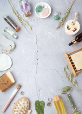 Sıfır atık sürdürülebilir kozmetik cilt bakım ürünleri ve gri taş arka planda çevre dostu banyo aksesuarları. İyileştirici kristaller, yeşil kuvars masajcı, gua sha.