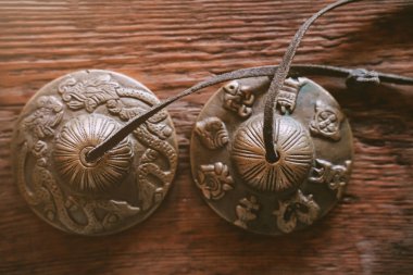 Hint Geleneksel Müzik Enstrümanları bronz karatallar. dini ritüeller, meditasyonlar ve alternatif tıp için bir obje. Tahta arka planda Tibet tapınağı çanları