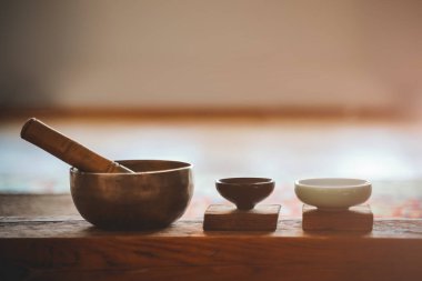 Meditasyon ve farkındalık için Tibet şarkı kasesi. Tahta bir yüzeyde küçük bir fincan çay