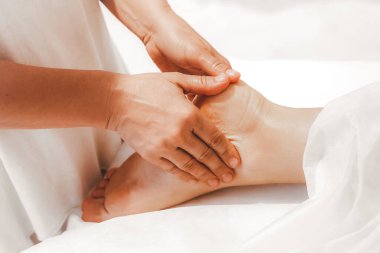 Yakın çekim masör elleri ayak masajı yapıyor. Seçici odak