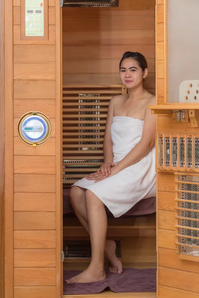 Mulher em cabine de sauna infravermelha — Fotografia de Stock