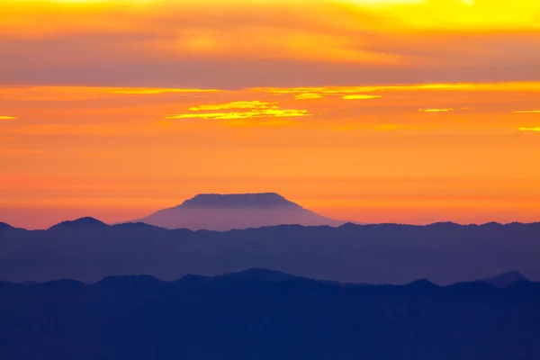 Blue mountain with orange sky while rising sun — Stock Photo, Image