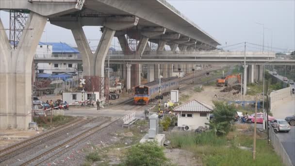 ときに停止道路上のトラフィックが 2014 日に高速道路建設現場の下ジャンクション経由で鉄道上実行列車バンコク 2014 — ストック動画