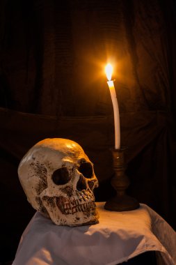 İnsan kafatası ve yanan mum