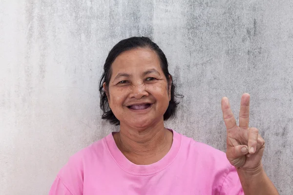 Smiling portrait of Thai woman and showing V sign — Stock Photo, Image