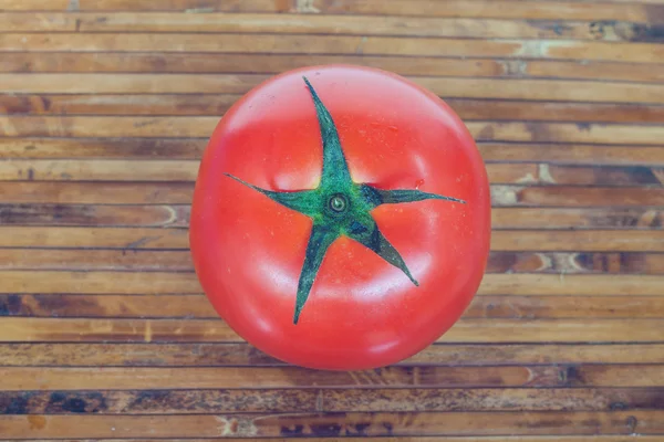 Red tomato on bamboo plate — Stock Photo, Image