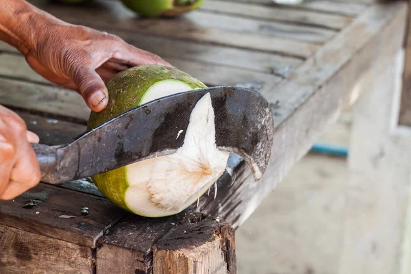Uomo che taglia il cocco con un grosso coltello — Foto Stock