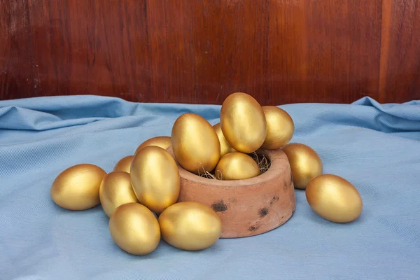 Empilement d'oeuf de Pâques doré dans un bol en argile cuite — Photo