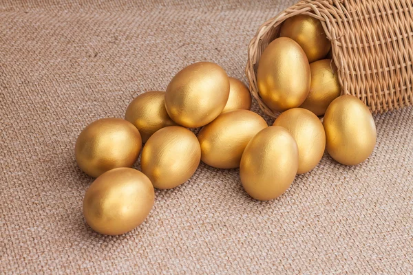 Tas d'oeuf de Pâques doré dans le panier en osier — Photo