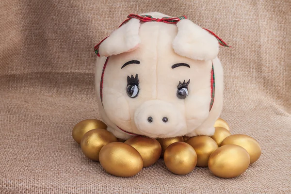 Χαριτωμένος χοίρου κούκλα στο χρυσό αυγό του Πάσχα — Φωτογραφία Αρχείου