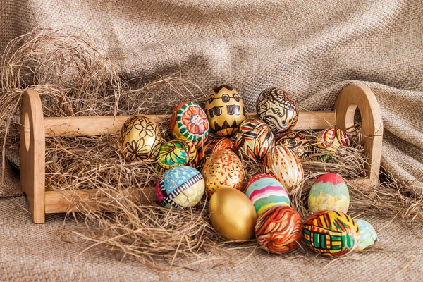 Colorato uovo di Pasqua dipinta sul fieno in mensola di legno — Foto Stock