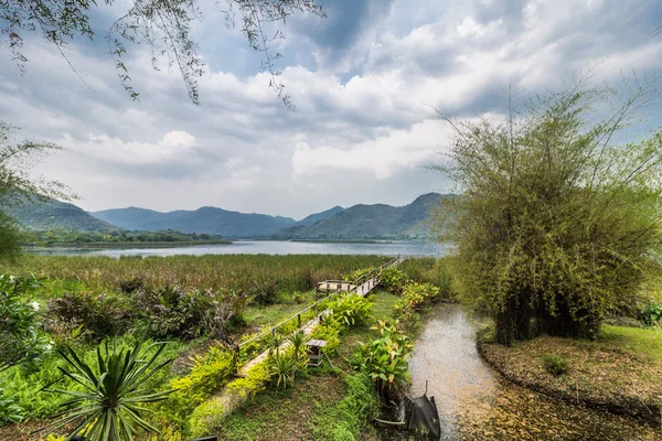 Ponte de bambu perto do reservatório com vista para a montanha e o céu — Fotografia de Stock