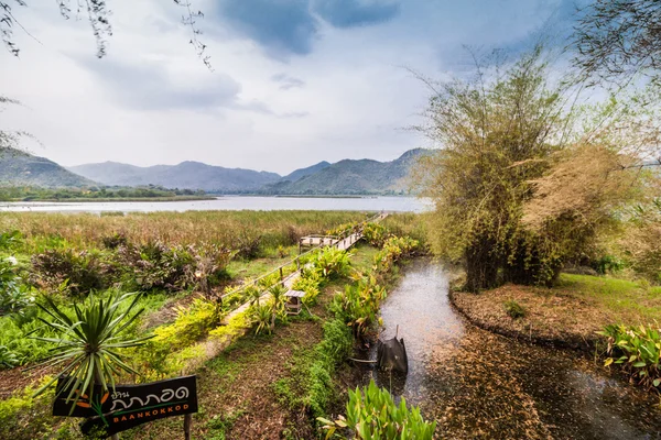 Ponte de bambu perto do reservatório com vista para a montanha e o céu — Fotografia de Stock