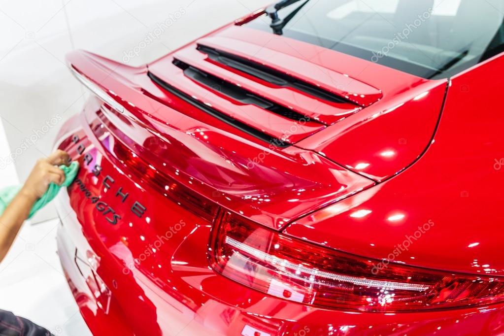 Nonthburi,Thailand - March 26th, 2015: Worker cleaning rear of  Porsche 911 Carrera 4 GTS ,an exceptional performance carr,showed in Thailand the 36th Bangkok International Motor Show on 26 March 2015