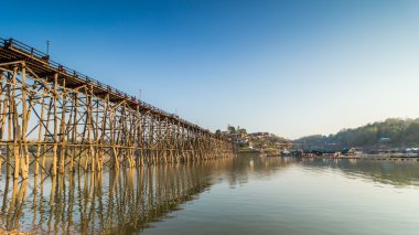 Dağ ve gökyüzü manzaralı rezervuar yakın bambu köprü