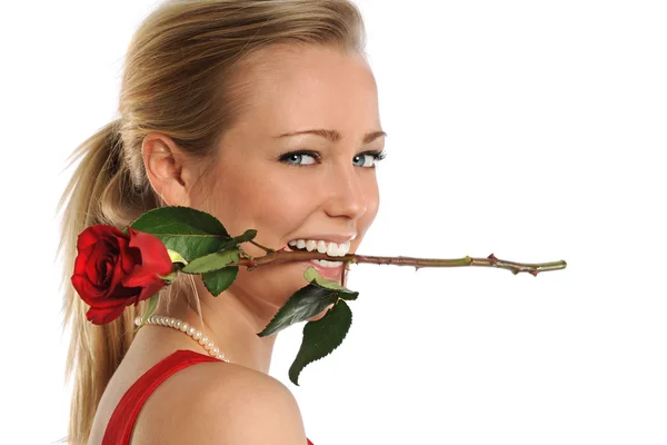 Молодая женщина кусающая розу — стоковое фото