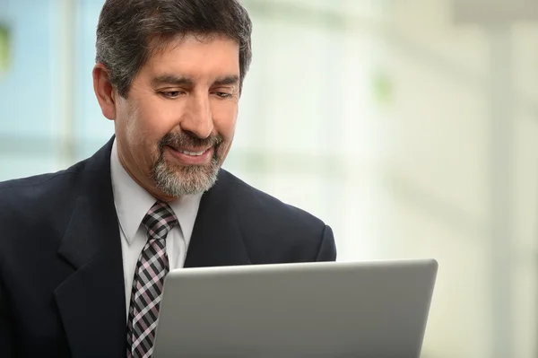 Homem de negócios hispânico usando laptop — Fotografia de Stock