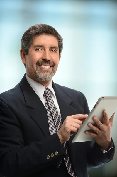 Homem de negócios hispânico usando comprimido eletrônico — Fotografia de Stock