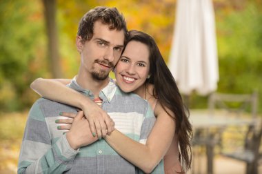 Genç çift arka bahçesinde kucaklayan