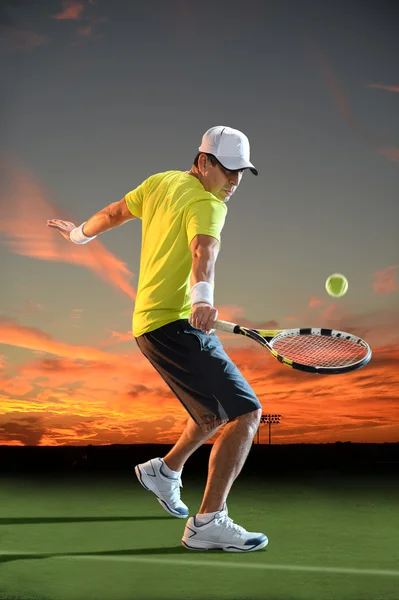 Homme jouant au tennis au coucher du soleil — Photo