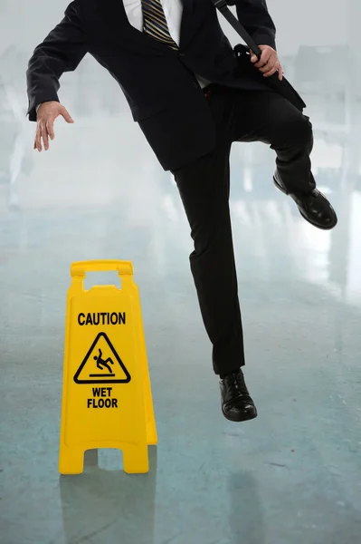 Empresário escorregando no chão molhado — Fotografia de Stock