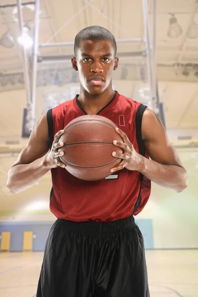 Jugador de baloncesto sosteniendo la pelota en el gimnasio — Foto de Stock