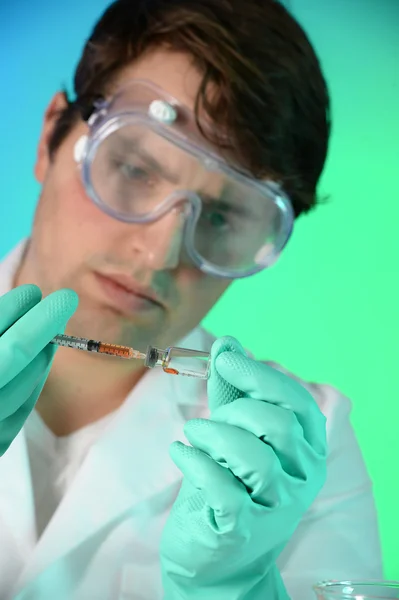 Vetenskapsman med sprutan och injektionsflaskan — Stockfoto