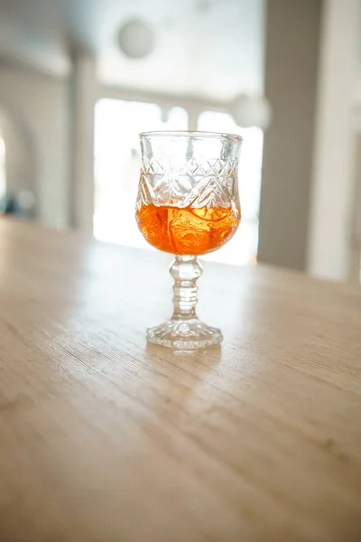 glass with orange drink on the table