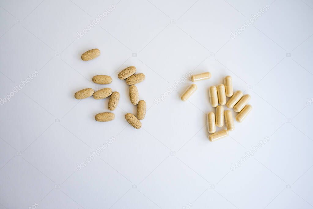 brown pills and capsules on a white background