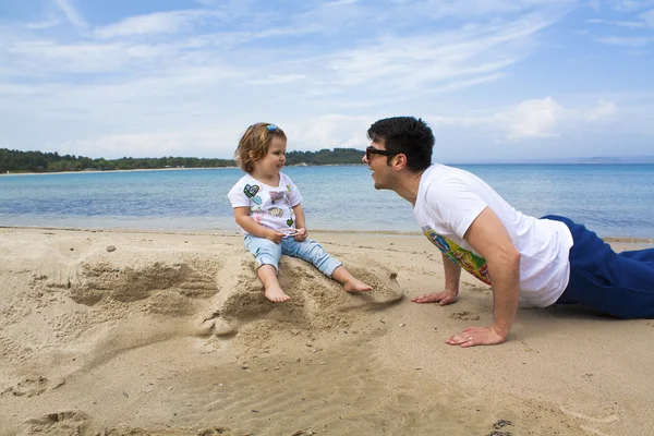 Vader en dochter plezier op het strand — Stockfoto