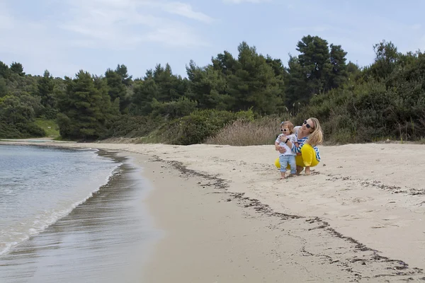 Anne ve küçük kızı bir plaj boyunca yürüyüş. — Stok fotoğraf