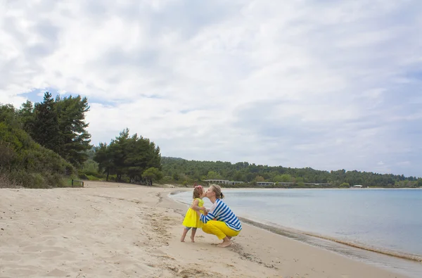 Mãe e sua filhinha andando ao longo de uma praia . — Fotografia de Stock