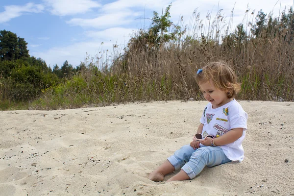 Kumsalda oynarken sevimli küçük kız. — Stok fotoğraf